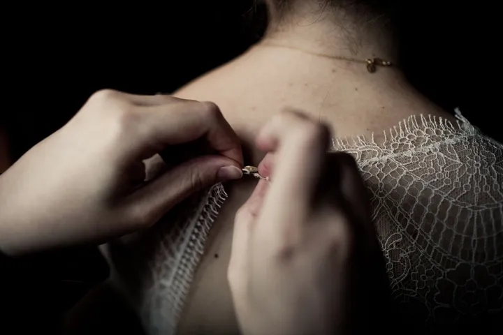 Mains qui examinent une dentelle au niveau de l’épaule
